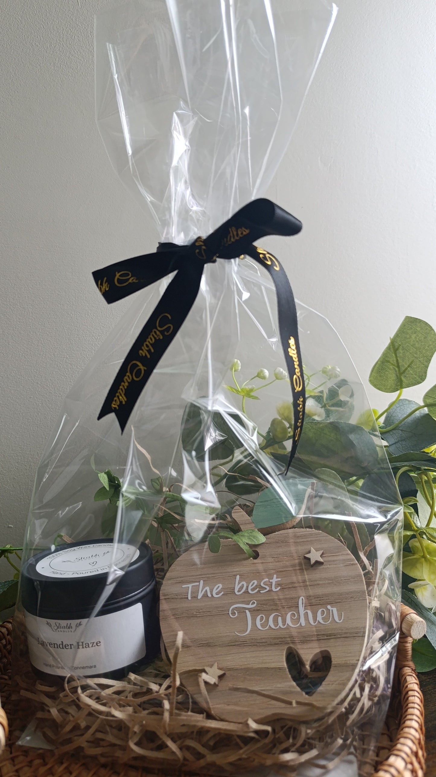 Gift basket with a jar and wooden tag reading 'The best teacher' on a white background.
