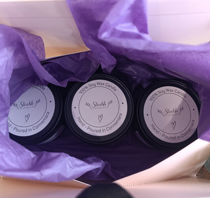 Three soy wax candles in a box with purple tissue paper