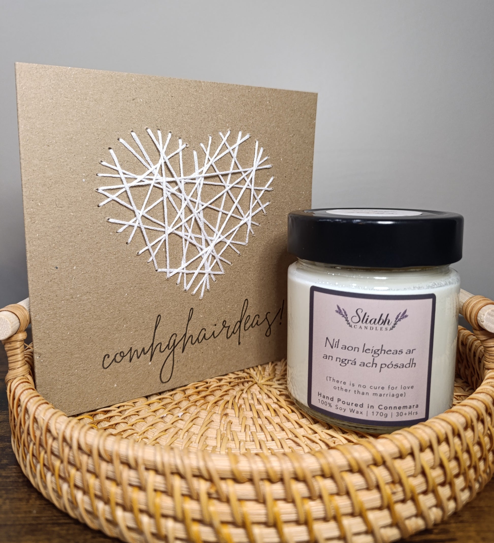 Candle jar with a decorative card on a woven tray